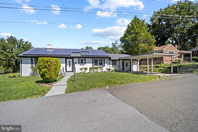 ranch-style house with a front lawn and solar panels