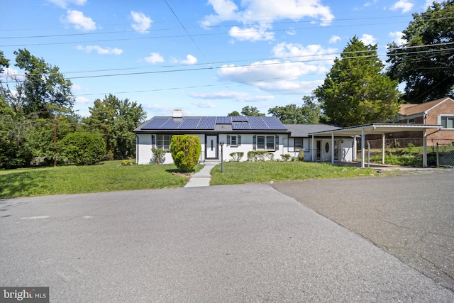 ranch-style house with solar panels and a front yard