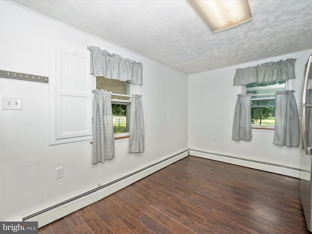 empty room with baseboard heating and dark hardwood / wood-style floors