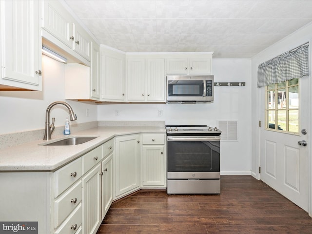 kitchen with white cabinets, sink, stainless steel appliances, and dark hardwood / wood-style flooring