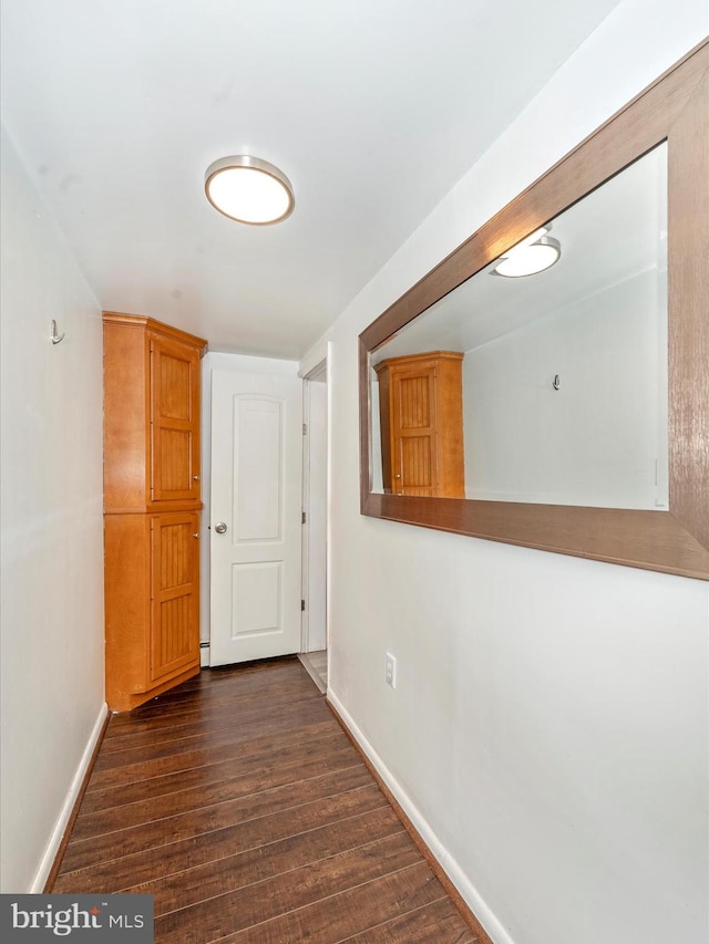 hallway with dark hardwood / wood-style flooring