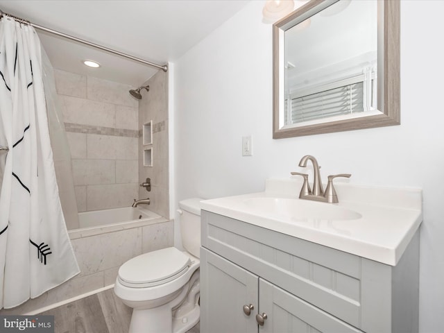 full bathroom with shower / tub combo with curtain, hardwood / wood-style flooring, vanity, and toilet