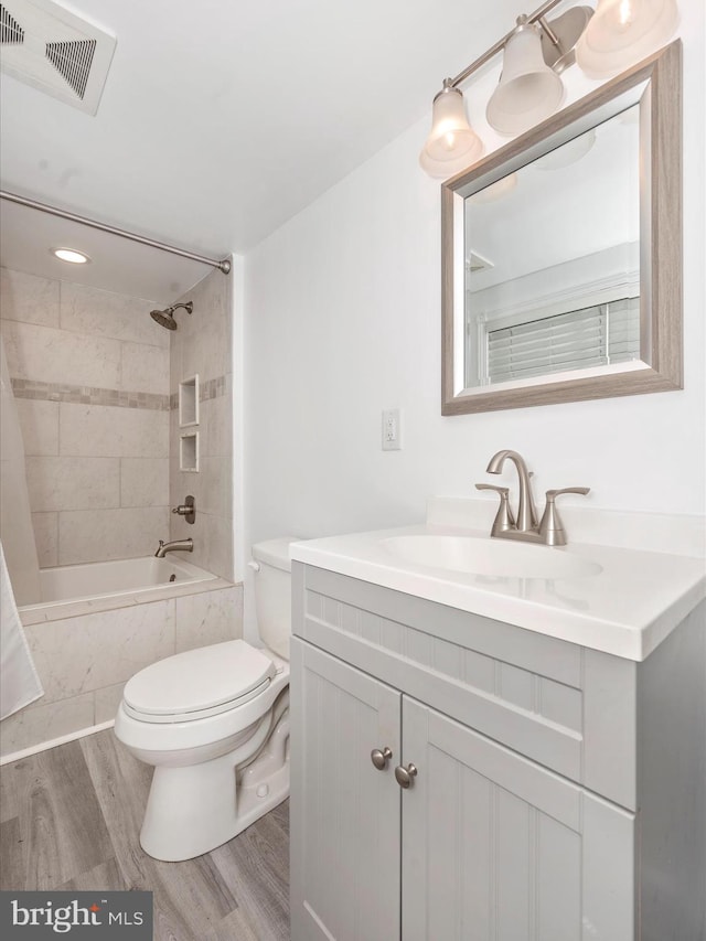 full bathroom with hardwood / wood-style flooring, vanity, toilet, and shower / bath combination with curtain