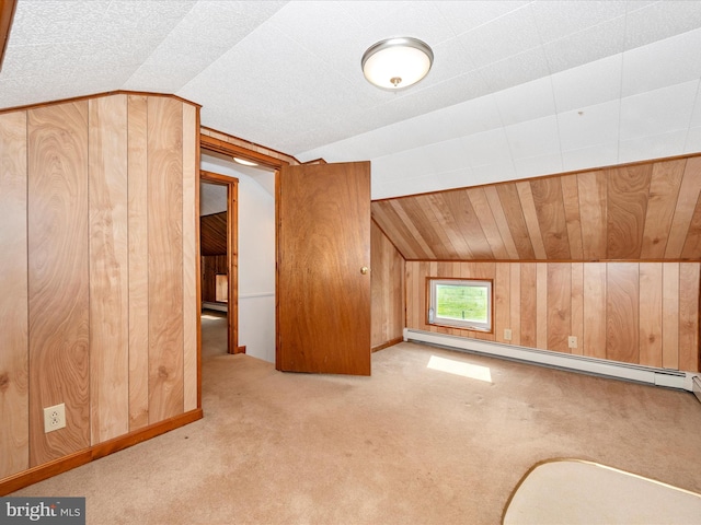 bonus room featuring baseboard heating, wooden walls, vaulted ceiling, and light colored carpet