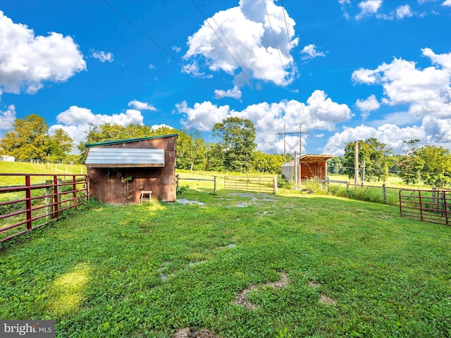 view of yard featuring a rural view and an outbuilding