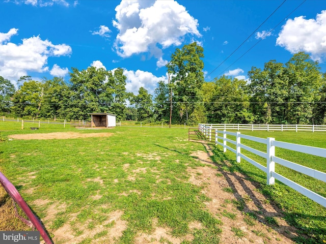 view of yard with an outdoor structure and a rural view