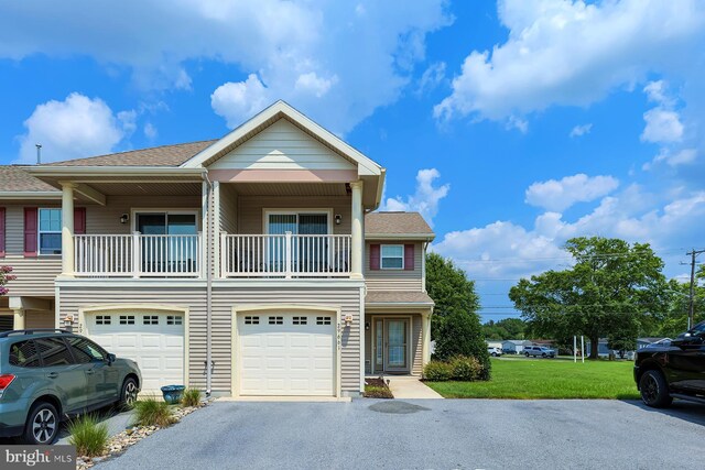 multi unit property featuring a balcony, a front yard, and a garage