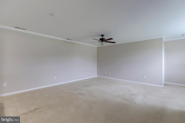 empty room with ornamental molding, visible vents, light carpet, and baseboards