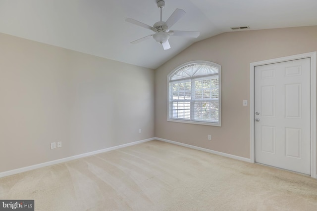 spare room featuring ceiling fan, light carpet, visible vents, baseboards, and vaulted ceiling