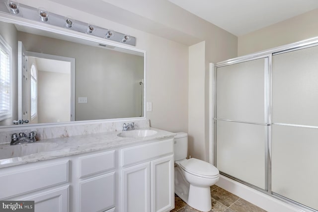 full bath with double vanity, a stall shower, and a sink