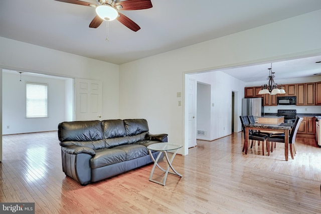 living room with light hardwood / wood-style flooring and ceiling fan