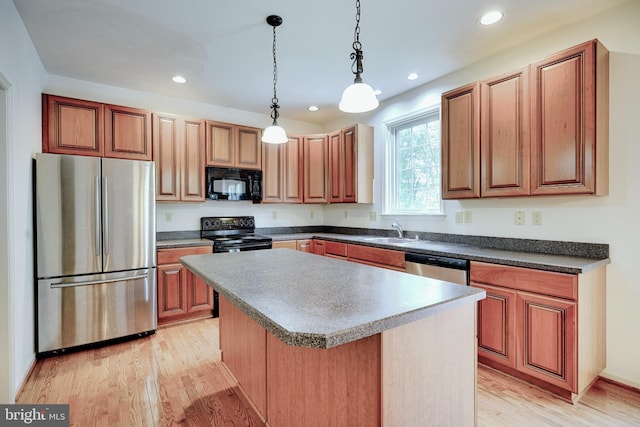 kitchen featuring a kitchen island, hanging light fixtures, light hardwood / wood-style floors, sink, and stainless steel appliances