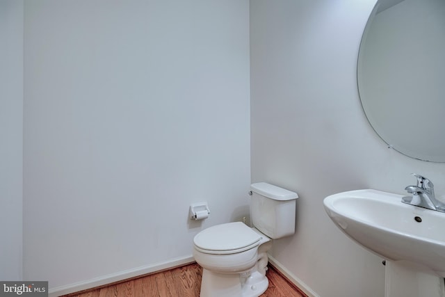 bathroom with hardwood / wood-style flooring, sink, and toilet