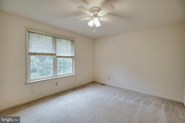 carpeted spare room with ceiling fan