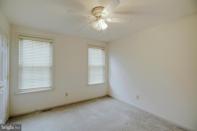 carpeted empty room with ceiling fan and a healthy amount of sunlight