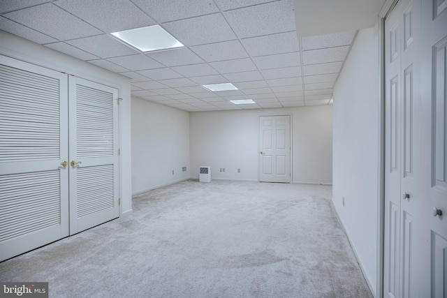 unfurnished bedroom featuring a paneled ceiling and light colored carpet