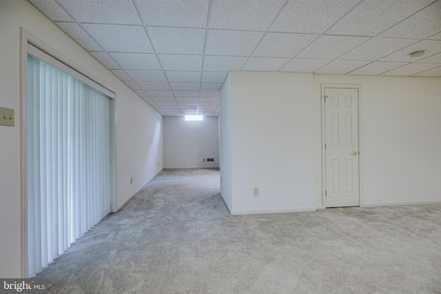 empty room featuring light colored carpet and a paneled ceiling