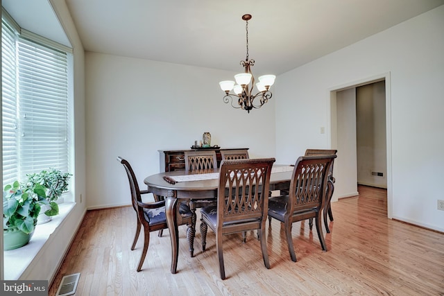 dining area with light hardwood / wood-style flooring, a chandelier, and plenty of natural light