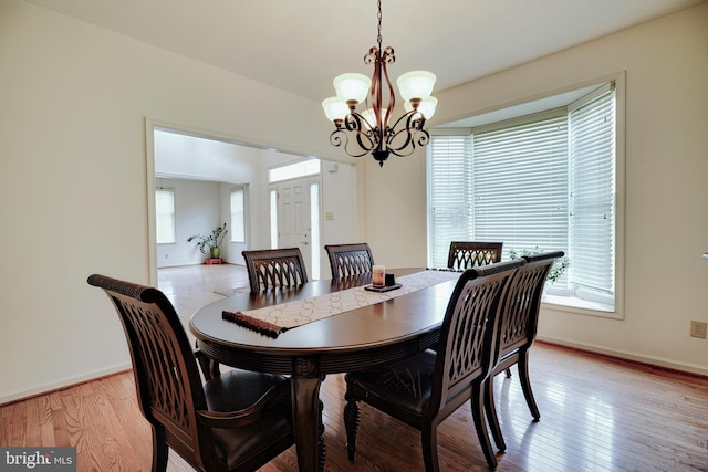 dining room featuring light wood-type flooring and a chandelier