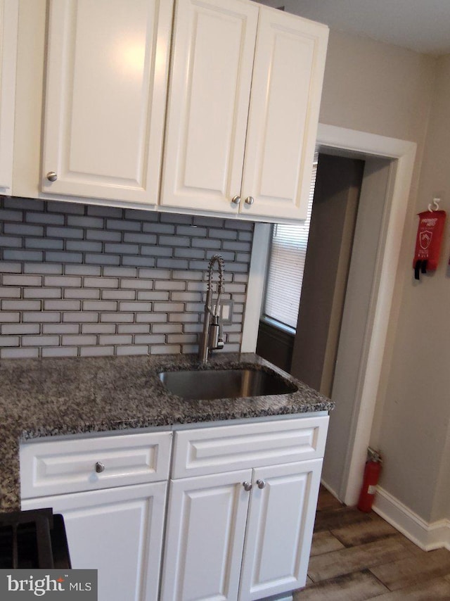 kitchen with white cabinets, backsplash, sink, and dark hardwood / wood-style floors