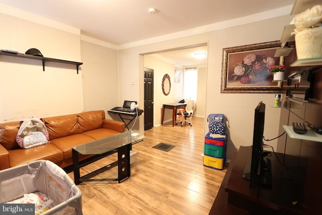 living room with crown molding and light hardwood / wood-style flooring