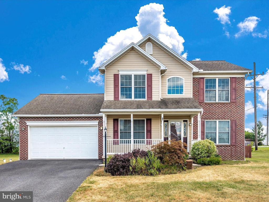 view of front of home featuring aphalt driveway, a garage, brick siding, roof with shingles, and a front lawn