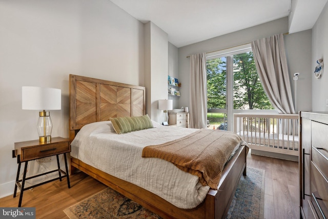 bedroom with vaulted ceiling, baseboards, and wood finished floors