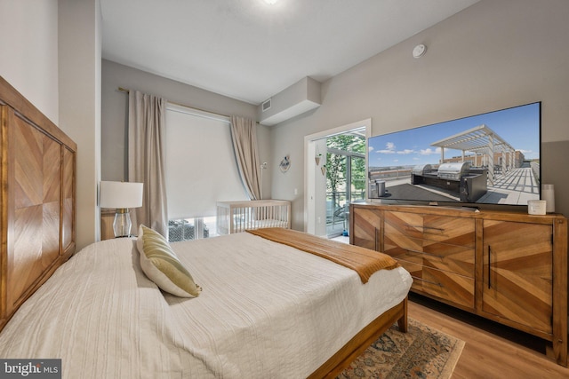 bedroom with access to outside, visible vents, and light wood-style flooring