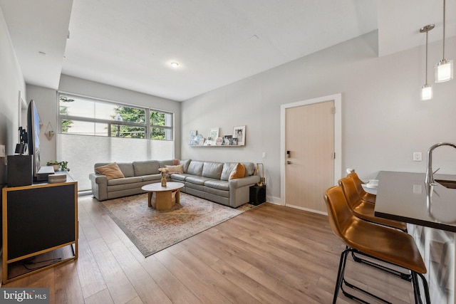 living area featuring light wood-style flooring and baseboards