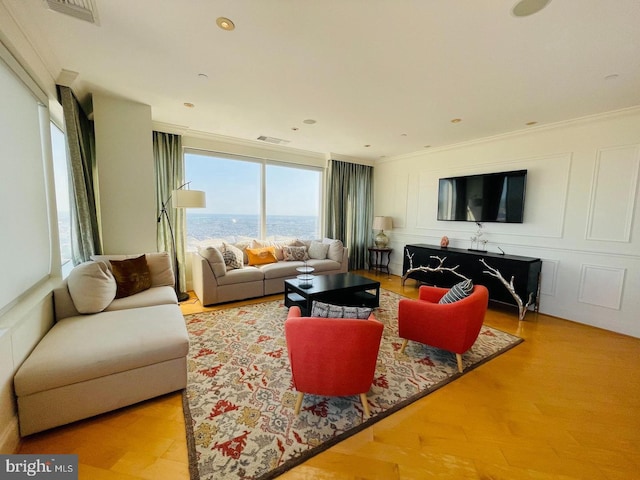 living room with light hardwood / wood-style flooring and ornamental molding