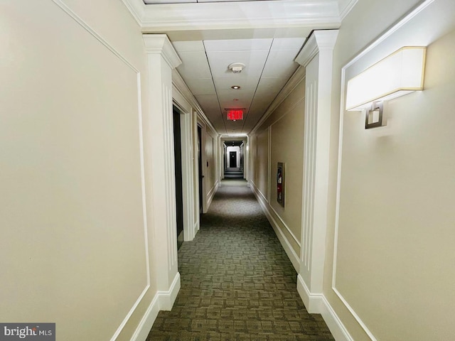 corridor featuring crown molding and dark carpet