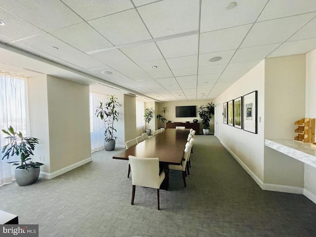 carpeted dining room featuring a drop ceiling