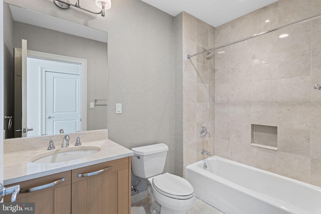 full bathroom featuring toilet, tiled shower / bath combo, and vanity