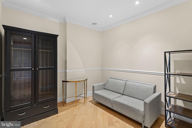 sitting room with crown molding and light hardwood / wood-style floors