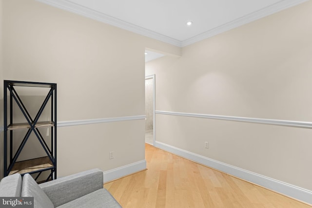 sitting room with light wood-type flooring and crown molding