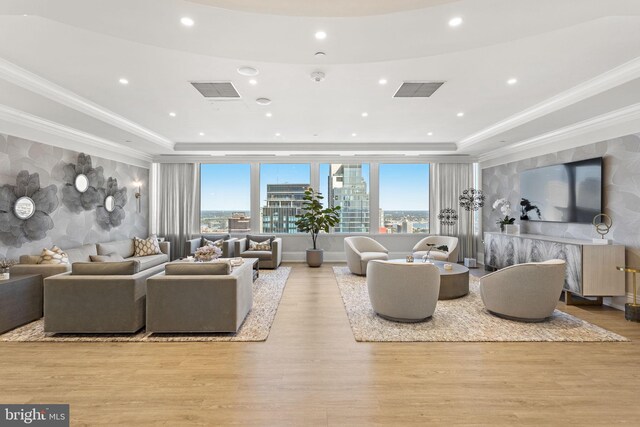 hallway featuring light parquet flooring, a tray ceiling, a chandelier, and elevator