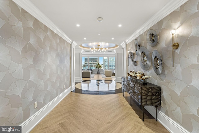 hallway with ornamental molding, a notable chandelier, and light parquet flooring