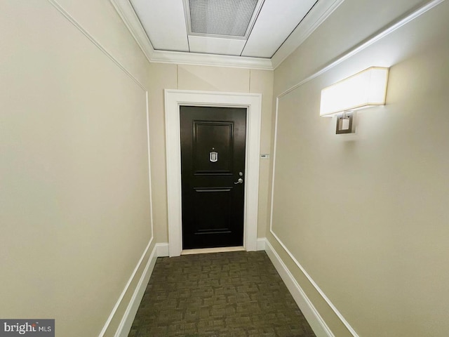 entryway featuring ornamental molding and dark carpet