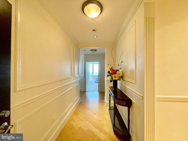 hallway featuring light hardwood / wood-style flooring and ornamental molding