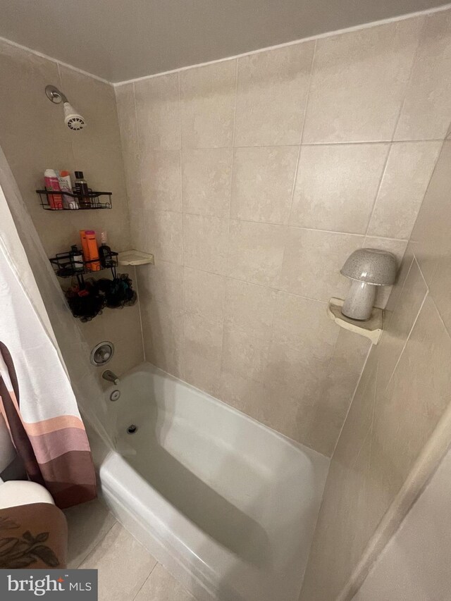 bathroom featuring tile patterned flooring, tile walls, and shower / tub combo