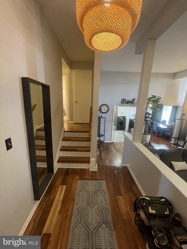 hallway featuring dark wood-style flooring, stairway, and baseboards