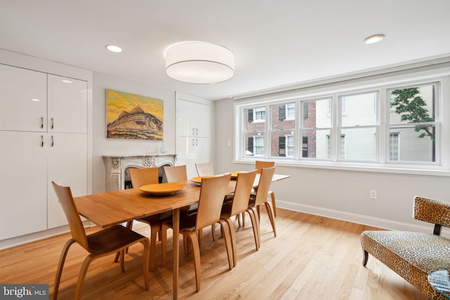 dining area with a premium fireplace and light hardwood / wood-style floors