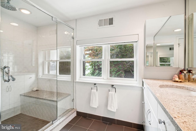 bathroom with vanity, a shower with shower door, and tile patterned flooring