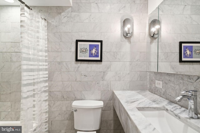 bathroom featuring walk in shower, vanity, tile walls, and toilet