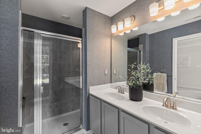 bathroom featuring an enclosed shower and double sink vanity