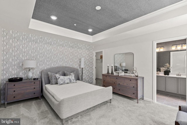 bedroom with sink, crown molding, light tile patterned floors, a tray ceiling, and connected bathroom