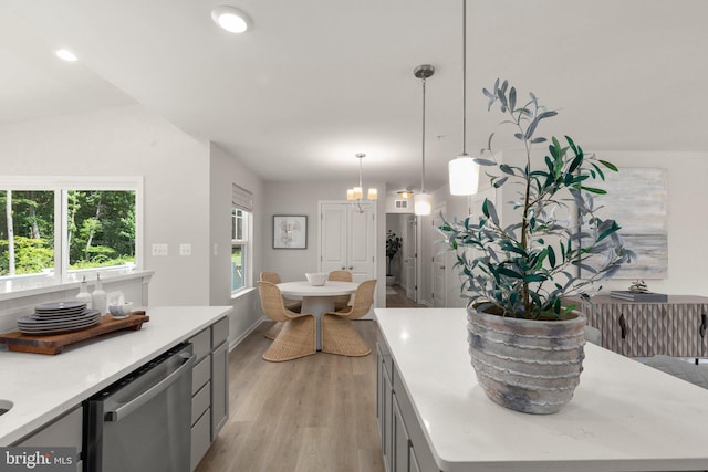 kitchen featuring light hardwood / wood-style flooring, pendant lighting, gray cabinets, vaulted ceiling, and dishwasher