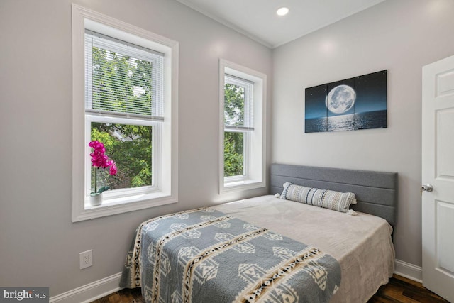 bedroom featuring dark hardwood / wood-style flooring and multiple windows