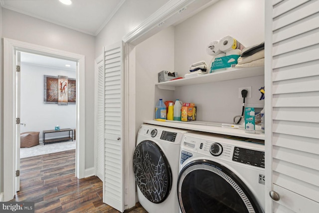 clothes washing area featuring dark wood-type flooring, separate washer and dryer, and ornamental molding