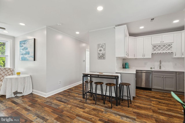 kitchen featuring decorative backsplash, stainless steel dishwasher, sink, white cabinets, and dark wood-type flooring